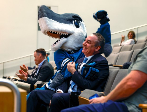 San Jose Sharks President Jonathan Becher and Sharks mascot S.J. Sharkie celebrate after the San Jose City Council agreed to the San Jose Sharks' lease extension at SAP Center until 2051 at San Jose City Hall in downtown in San Jose, Calif., on Tuesday, Aug. 26, 2025. (Nhat V. Meyer/Bay Area News Group)