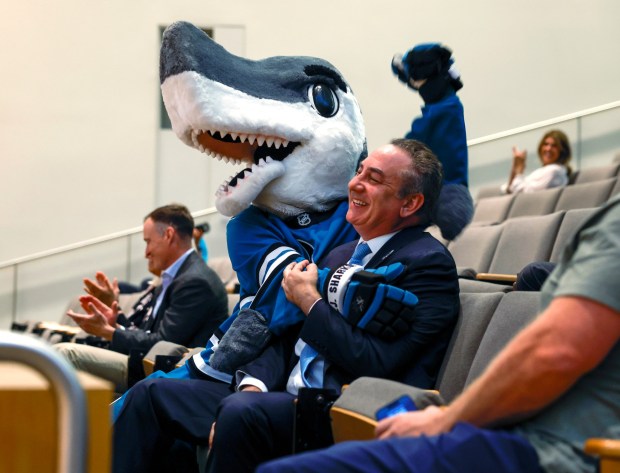 San Jose Sharks President Jonathan Becher and Sharks mascot S.J. Sharkie celebrate after the San Jose City Council agreed to the San Jose Sharks' lease extension at SAP Center until 2051 at San Jose City Hall in downtown in San Jose, Calif., on Tuesday, Aug. 26, 2025. (Nhat V. Meyer/Bay Area News Group)