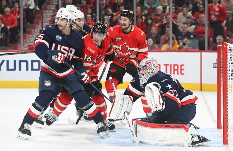Canada's Mitch Marner (16) and Mark Stone (61) move in on United States goaltender Connor Hellebuyck (37) as United States' Noah Hanifin (15) defends during third period 4 Nations Face-Off hockey action in Montreal, Saturday, Feb. 15, 2025.
