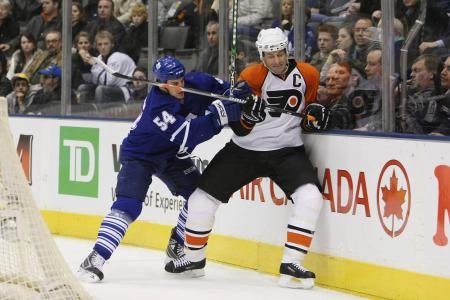 Toronto Maple Leafs forward Kris Newbury finishing off a check against Philadelphia Flyers defenseman Jason Smith. Toronto Maple Leafs forward Kris Newbury finishing off a check against Philadelphia Flyers defenseman Jason Smith.