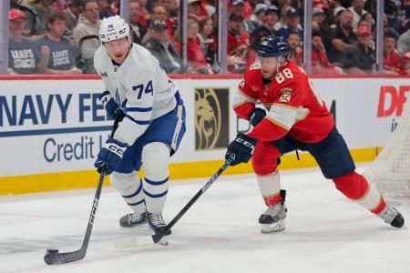 Toronto Maple Leafs forward Bobby McMann protecting the puck against Florida Panthers defenseman Nate Schmidt. Toronto Maple Leafs forward Bobby McMann protecting the puck against Florida Panthers defenseman Nate Schmidt.
