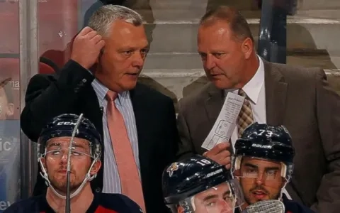 Former Vancouver Canucks Assistant Coach Mike Kelly (left) behind the bench with the Florida Panthers.