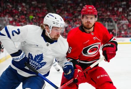 Apr 13, 2025; Raleigh, North Carolina, USA; Carolina Hurricanes center Jack Roslovic (96) and Toronto Maple Leafs defenseman Simon Benoit (2) chase after the play during the first period at Lenovo Center