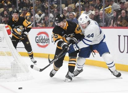 Nov 25, 2023; Pittsburgh, Pennsylvania, USA; Pittsburgh Penguins defenseman Erik Karlsson (65) and Toronto Maple Leafs defenseman Morgan Rielly (44) go for the puck during the second period at PPG Paints Arena. Mandatory Credit: Philip G. Pavely-Imagn Images