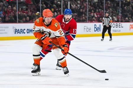 Dec 9, 2024; Montreal, Quebec, CAN; Anaheim Ducks center Mason McTavish (23) plays the puck against Montreal Canadiens right wing Josh Anderson (17) during the first period at Bell Centre. Mandatory Credit: David Kirouac-Imagn Images