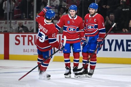 Feb 25, 2025; Montreal, Quebec, CAN; Montreal Canadiens defenseman Lane Hutson (48) celebrates with right wing Cole Caufield (13) and center Nick Suzuki (14) his goal against the Carolina Hurricanes in the third period at Bell Centre. Mandatory Credit: David Kirouac-Imagn Images