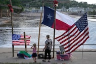 Nancy Epperson, right, and Brooklyn Pucek, 6, visit a memorial for flood victims along the...