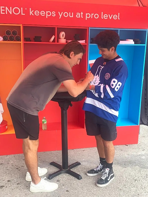 Maple Leafs winger Matthew Knies signs a jersey for a fan at a promotional event on Saturday. (Lance Hornby, Toronto Sun)
