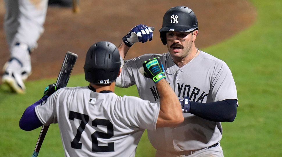 New York Yankees' Austin Wells (28) celebrates with José Caballero (72) after Wells hit a home run off Tampa Bay Rays pitcher Pete Fairbanks during the 10th inning of a baseball game Wednesday, Aug. 20, 2025, in Tampa, Fla. (AP Photo/Chris O'Meara)