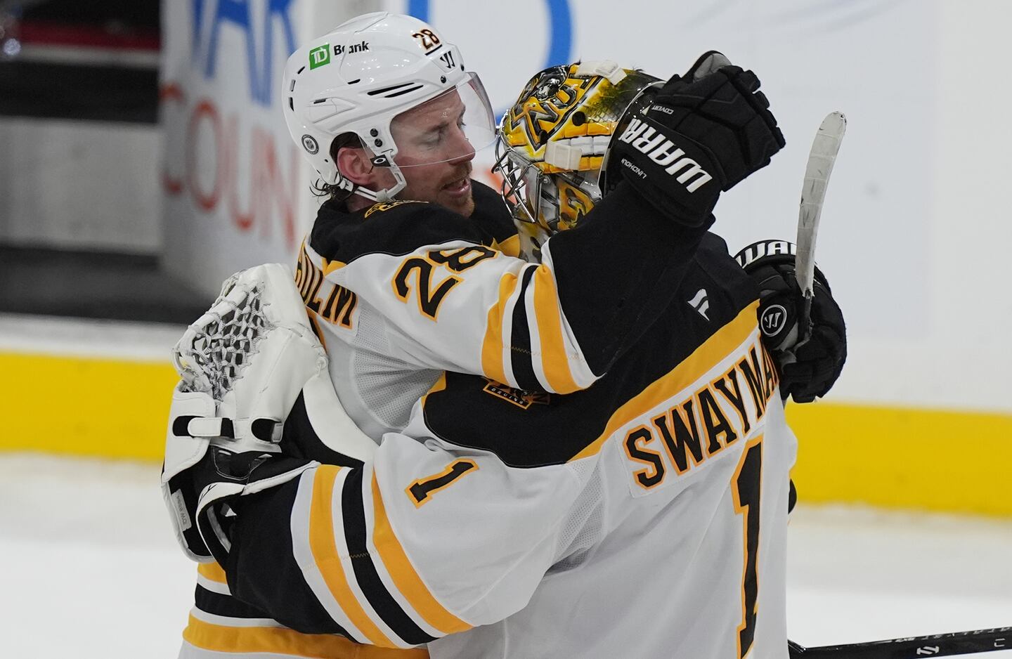 Elias Lindholm and Jeremy Swayman embrace after Saturday's victory.