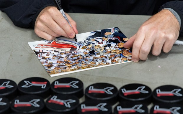 Former Blackhawks right winger Patrick Kane signs his autograph on a picture of one of his three winning Stanley Cup teams with the Blackhawks for a youth hockey player during Patrick Kane Day Friday, Aug. 8, 2025 at Johnny's Ice House West in the United Center neighborhood of Chicago. The City of Chicago officially named Aug. 8 Patrick Kane Day. Kane donated multiple items to the youth that attended the skate around including hockey sticks, helmets, gloves and more.(Dominic Di Palermo/Chicago Tribune)