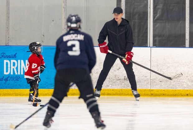 Former Blackhawks right wing Patrick Kane, right, passes the puck around with youth hockey players during Patrick Kane Day Friday, Aug. 8, 2025 at Johnny's Ice House West in the United Center neighborhood of Chicago. The City of Chicago officially named Aug. 8 Patrick Kane Day. Kane's son Patrick Kane III, left, attended the event with him. (Dominic Di Palermo/Chicago Tribune)