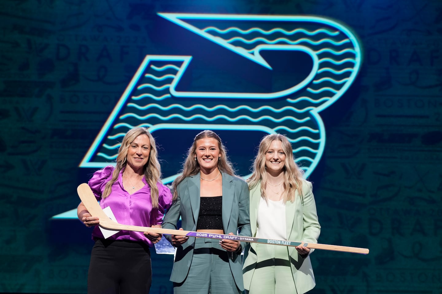 Haley Winn, center, posed for a photo after the Boston Fleet selected her during the first round of the PWHL draft.
