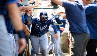 Tampa Bay Rays' Junior Caminero is greeted by teammates in the dugout after hitting a home run during the third inning of a baseball game against the Los Angeles Angels Wednesday, Aug. 6, 2025, in Anaheim, Calif. (AP Photo/William Liang)