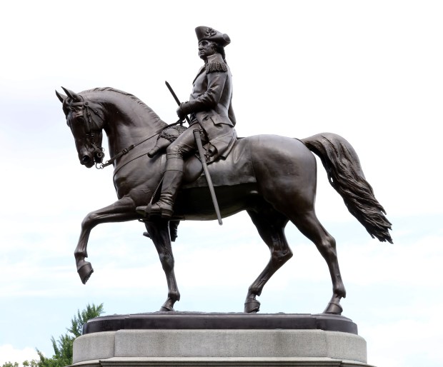 The George Washington statue sits high on the a pedestal at the entrance to the Boston Public Garden. (Mark Stockwell/Boston Herald)