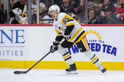 Pittsburgh Penguins defenseman Erik Karlsson handles the puck during 2024 game.