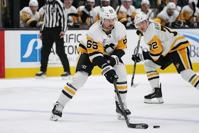 Pittsburgh Penguins defenseman Erik Karlsson skates with the puck during 2025 game.