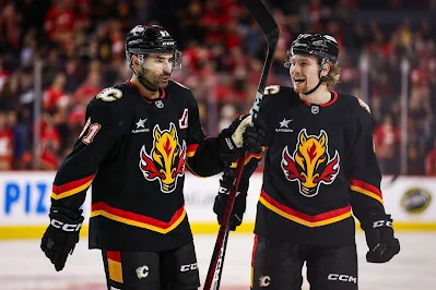 Calgary Flames forward Connor Zary & Nazem Kadri react during 2025 game.