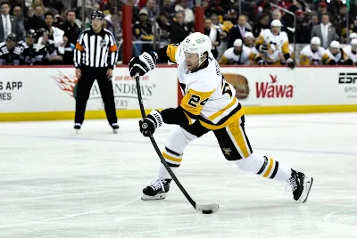 Pittsburgh Penguins defenseman Matt Grzelcyk shoots the puck during 2025 game.