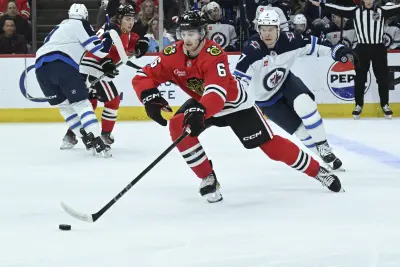 Apr 12, 2025; Chicago, Illinois, USA;  Chicago Blackhawks defenseman Sam Rinzel (6) and Winnipeg Jets center Vladislav Namestnikov (7) chase the puck during the first period at United Center. Mandatory Credit: Matt Marton-Imagn Images