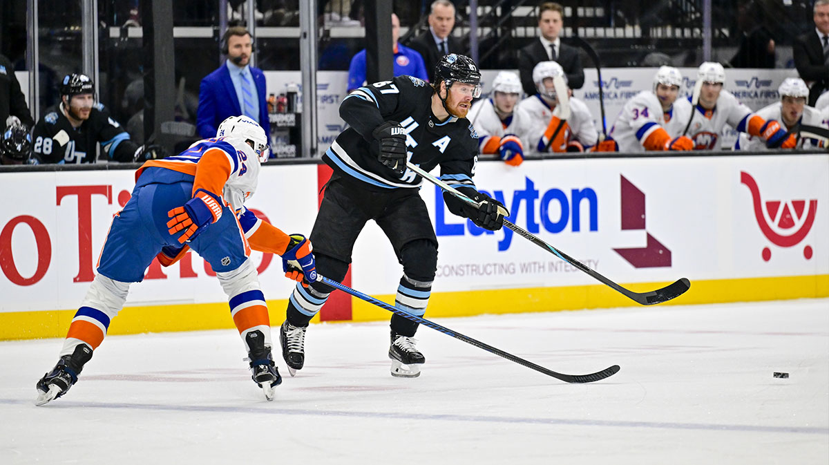 Utah Hockey Club left wing Lawson Crouse (67) passes the puck around New York Islanders defenseman Scott Mayfield (24) during second period at the Delta Center.
