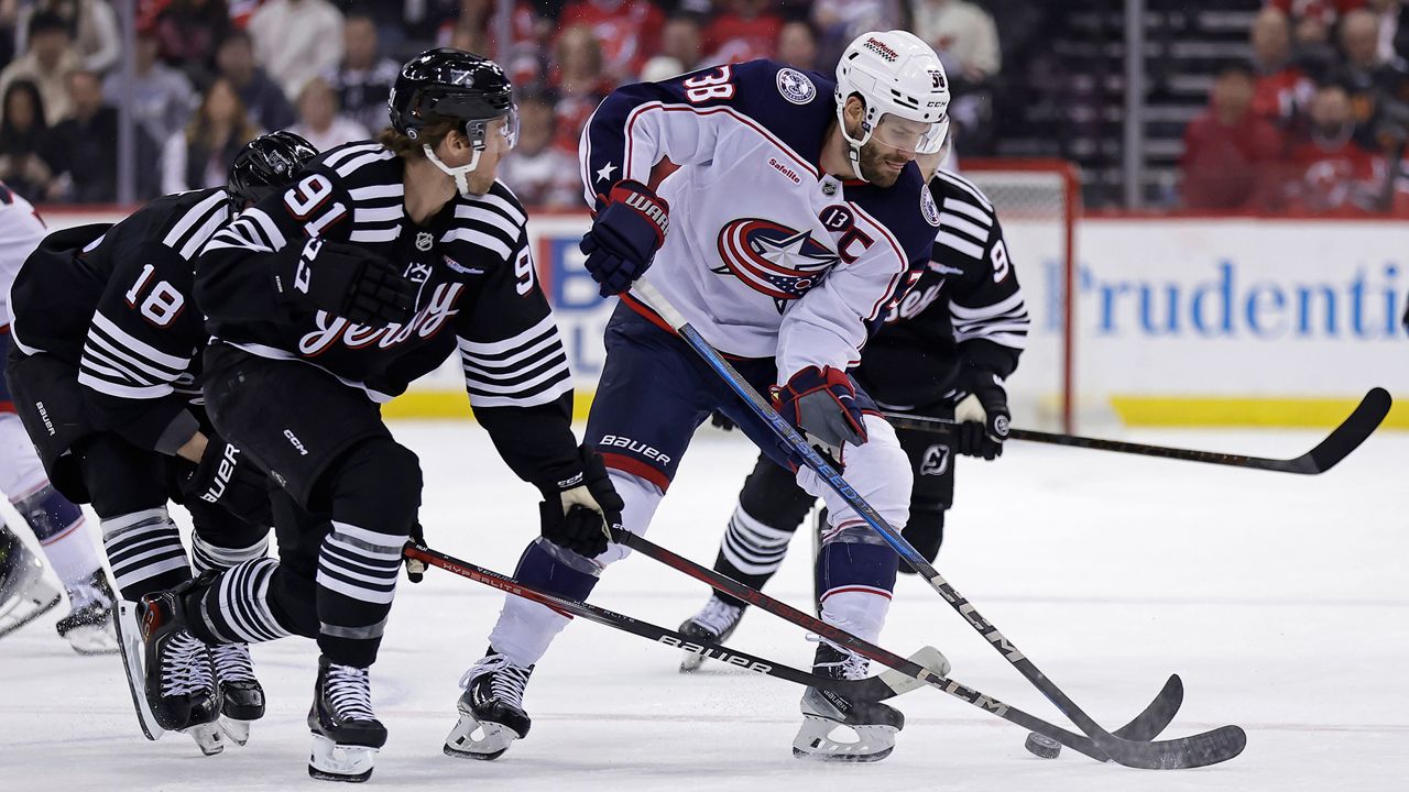 Columbus Blue Jackets center Boone Jenner (38) battles for the puck with New Jersey Devils center Dawson Mercer (91) during the first period of an NHL hockey game Tuesday, March 11, 2025, in Newark, N.J. (AP Photo/Adam Hunger)