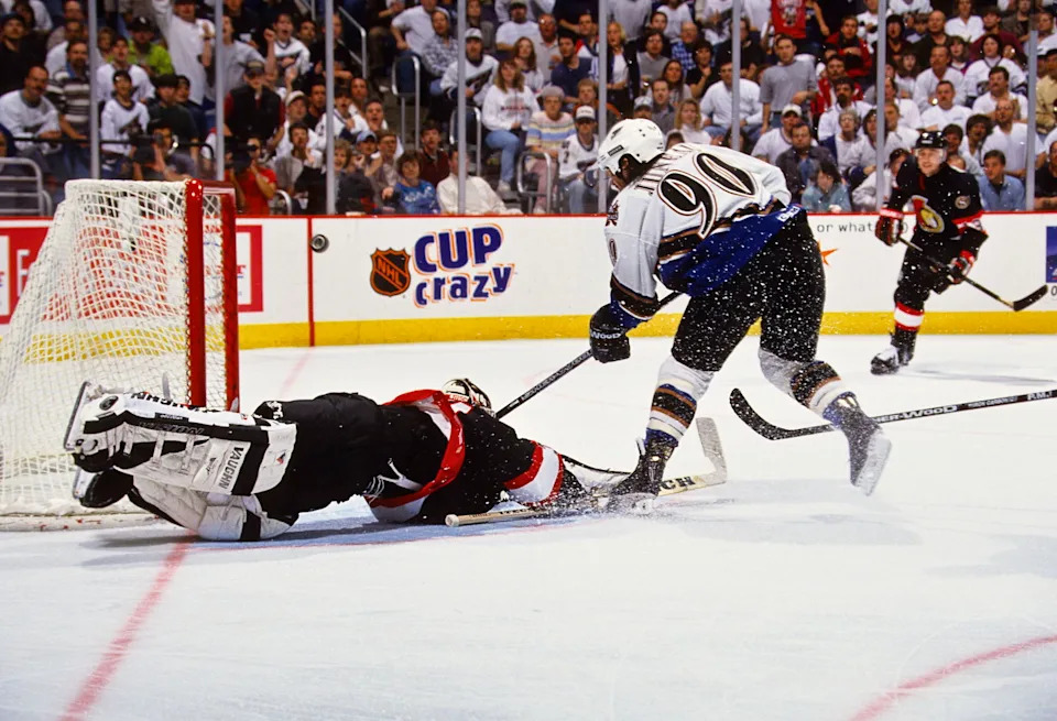 Unknown Date, 1998; Washington, DC, USA; FILE PHOTO; Washington Capitals center Joe Juneau (90) scores a goal against Ottawa Senators goalie Ron Tugnutt (31) at the MCI Center. Mandatory Credit: Lou Capozzola-USA TODAY NETWORK