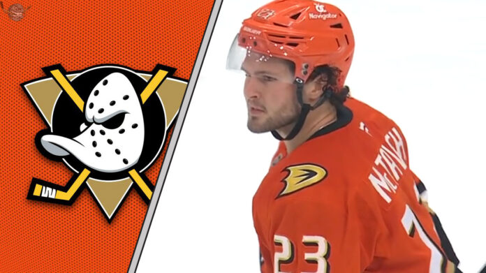 mason-mctavish-ducks-rumors-contract-2025 Anaheim Ducks center Mason McTavish skates with the puck during an NHL game, with Anaheim Ducks logo in the background