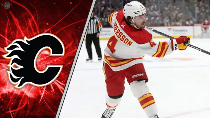 Calgary Flames defenseman Rasmus Andersson taking a shot during an NHL game, with a focus on the ongoing NHL trade rumors surrounding him