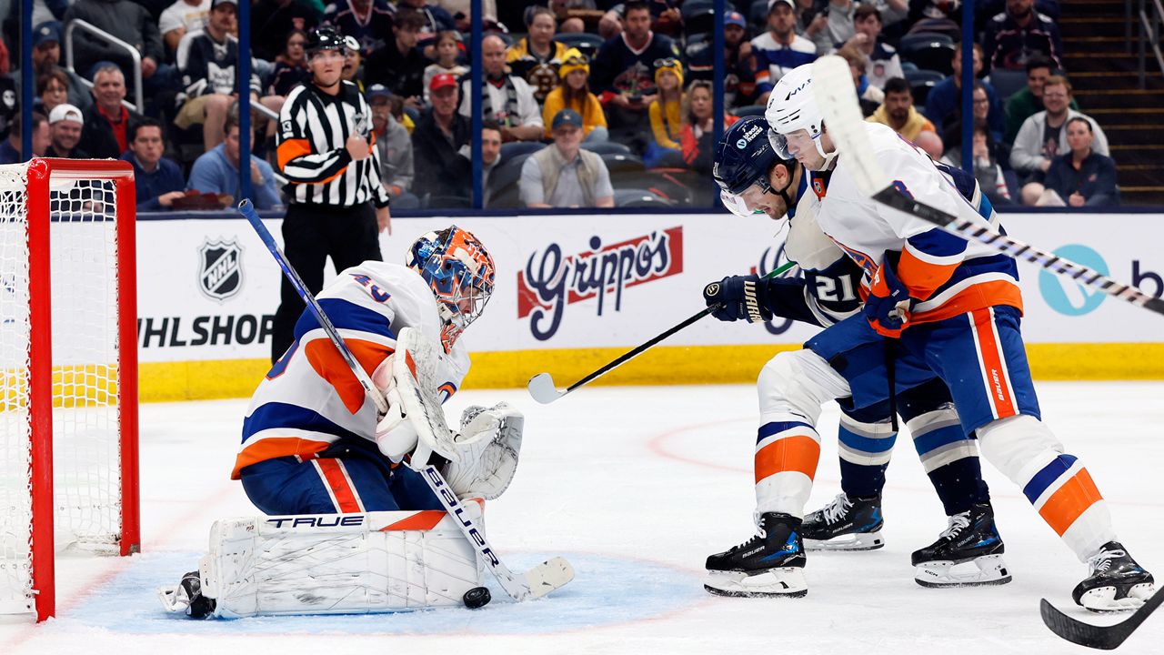 New York Islanders' Semyon Varlamov, left, makes a save as teammate Noah Dobson, right, and Columbus Blue Jackets' James van Riemsdyk look for the rebound during the second period of an NHL hockey game Wednesday, Oct. 30, 2024, in Columbus, Ohio. (AP Photo/Jay LaPrete)