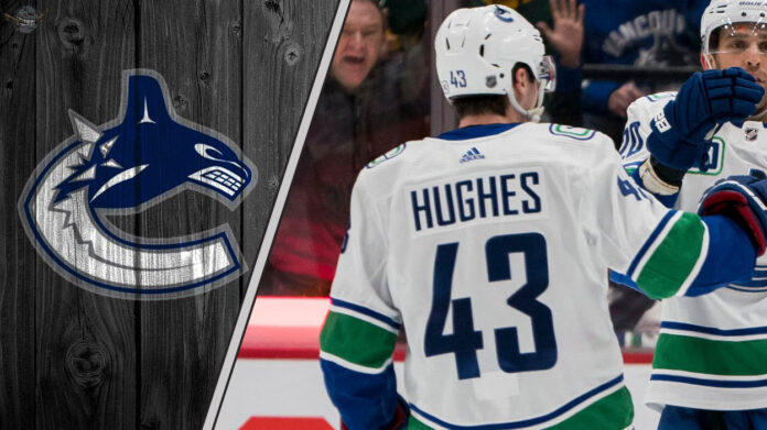 Vancouver Canucks captain Quinn Hughes looks on during a game, representing the focus of current NHL trade rumors