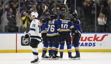 Apr 15, 2025; St. Louis, Missouri, USA; Utah Hockey Club center Alexander Kerfoot (15) looks on as St. Louis Blues right wing Zack Bolduc (76) is congratulated by teammates for scoring a goal during the first period at Enterprise Center. Mandatory Credit: Jeff Le-Imagn Images