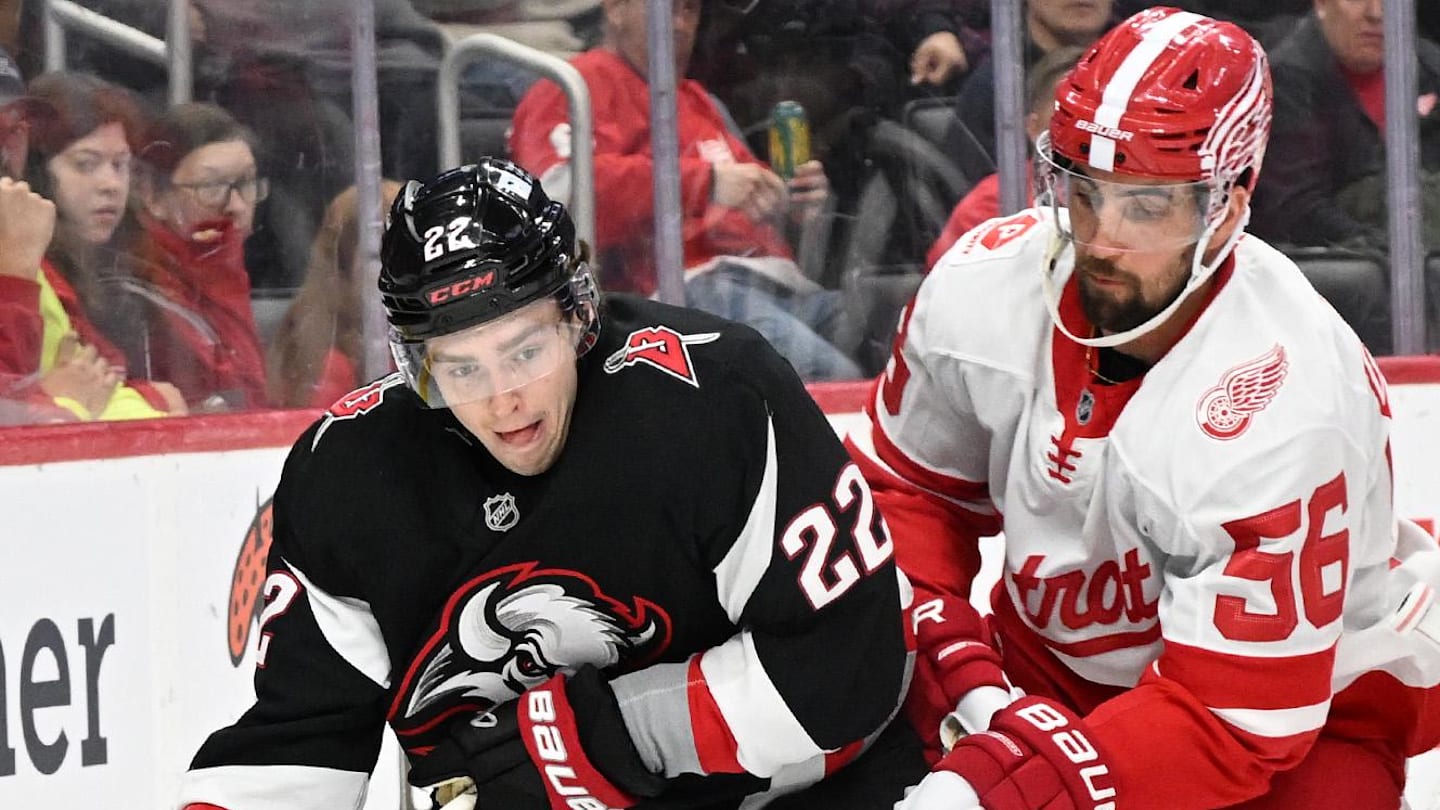 Mar 12, 2025; Detroit, Michigan, USA;  Buffalo Sabres right wing Jack Quinn (22) skates the puck behind the Detroit Red Wings goal as Red Wings defenseman Erik Gustafsson (56) defends in the first period at Little Caesars Arena. Mandatory Credit: Lon Horwedel-Imagn Images