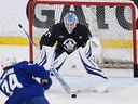 Toronto Maple Leafs goalie Joseph Woll prepares to make a save on winger Bobby McMann during training camp.