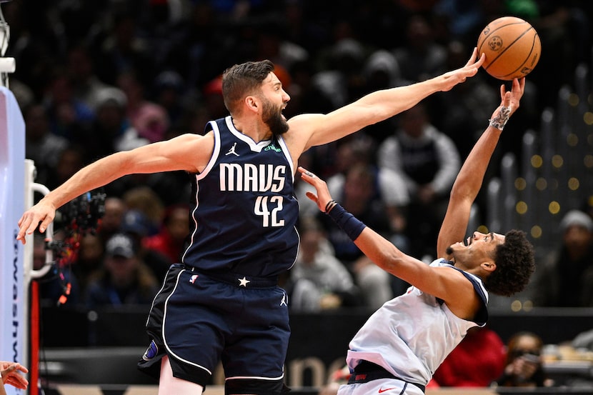Washington Wizards guard Jordan Poole, right, tries to shoot against Dallas Mavericks...