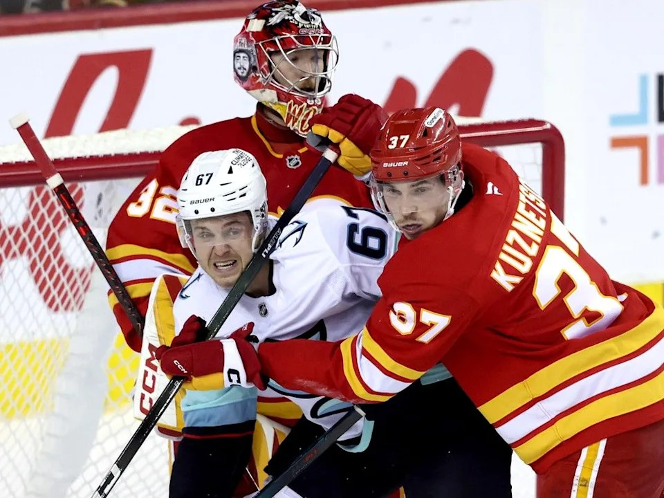 Flames defenceman Yan Kuznetsov battles Kraken forward Mitchell Stephens on Tuesday.