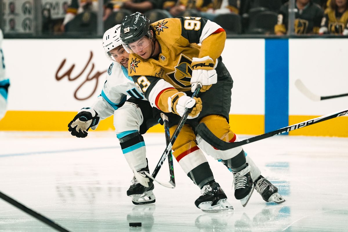 Vegas Golden Knights forward Mitch Marner (93) and Utah Mammoth right wing Dylan Guenther (11) reach for control of the puck during first period of NHL preseason game against Utah Mammoth on Thursday, Sept. 23, 2025 in Las Vegas.
