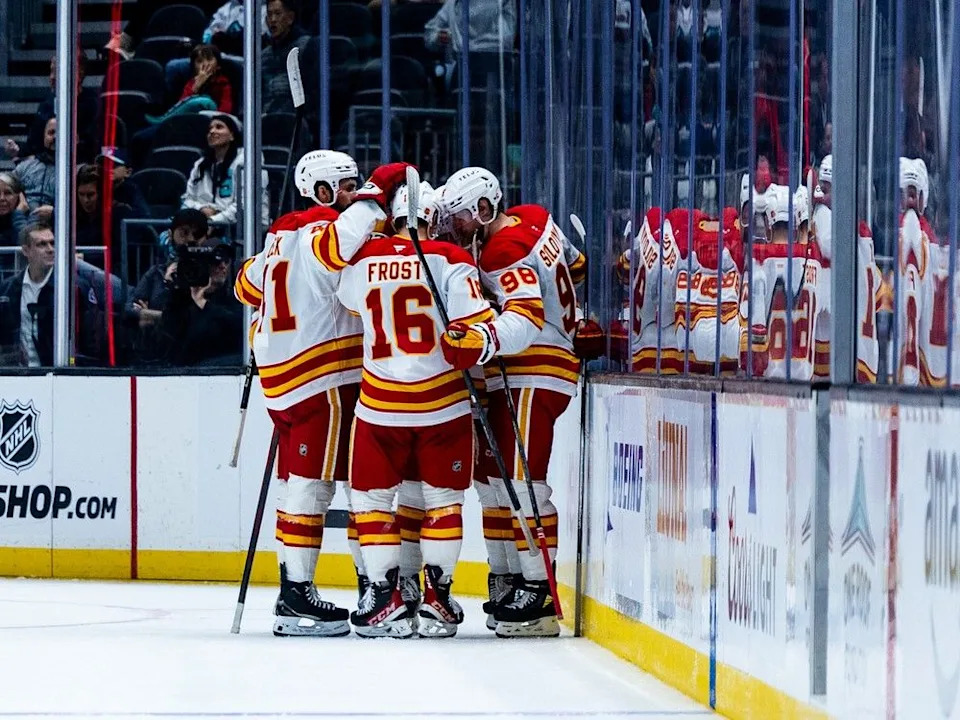 Calgary Flames players celebrate after right wing Matvei Gridin scored during the second period of an NHL hockey game against the Seattle Kraken, Monday, Sept. 29, 2025, in Seattle.