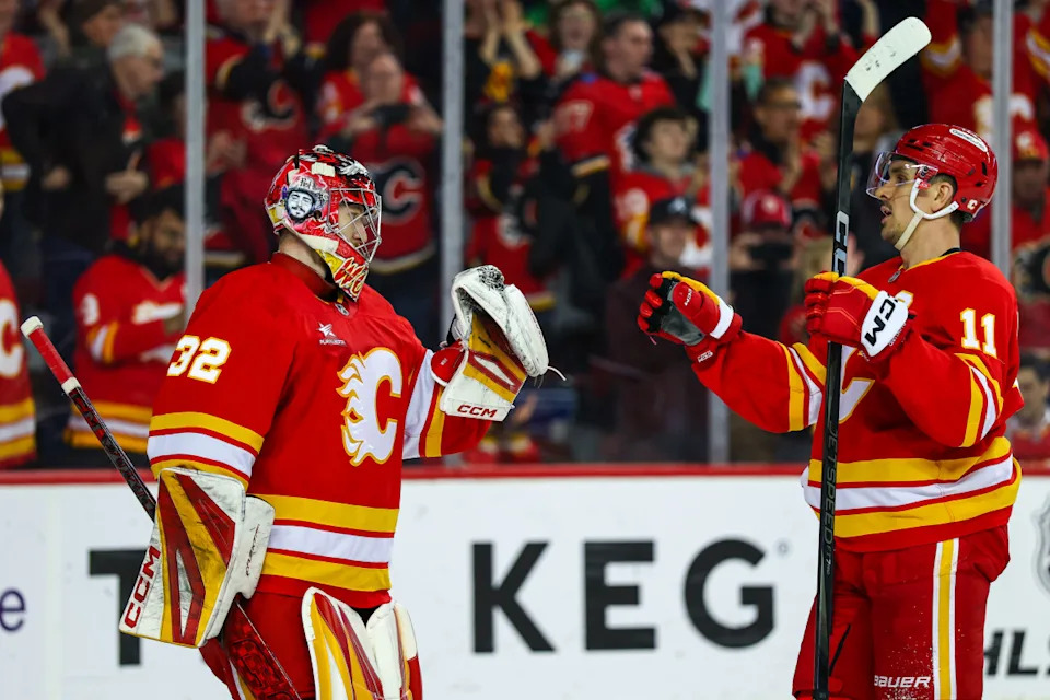 Apr 11, 2025; Calgary, Alberta, CAN; Calgary Flames goaltender Dustin Wolf (32) celebrate win with center Mikael Backlund (11) after defeating the Minnesota Wild at Scotiabank Saddledome. Mandatory Credit: Sergei Belski-Imagn ImagesSergei Belski-Imagn Images
