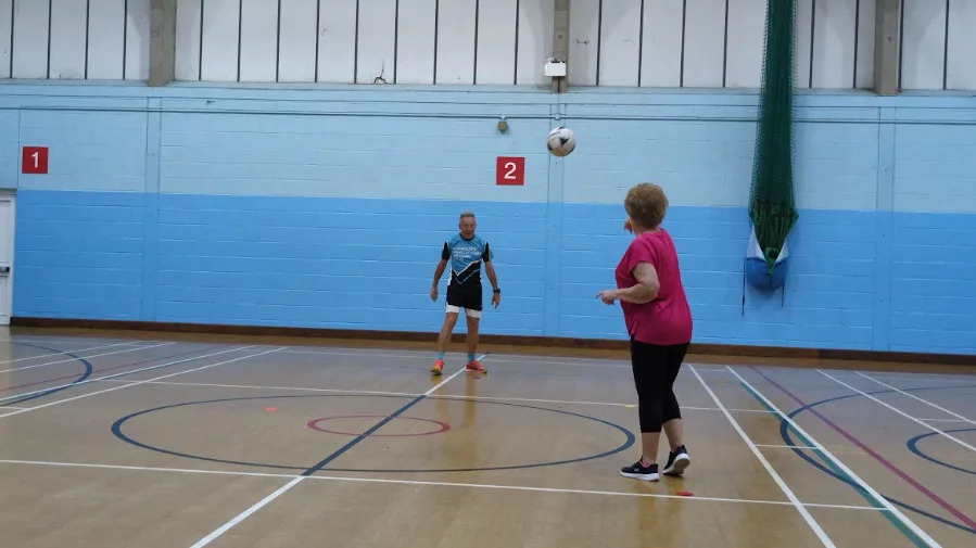 Gary Shaughnessy is in a sport hall and wearing black shorts and a blue sport top,