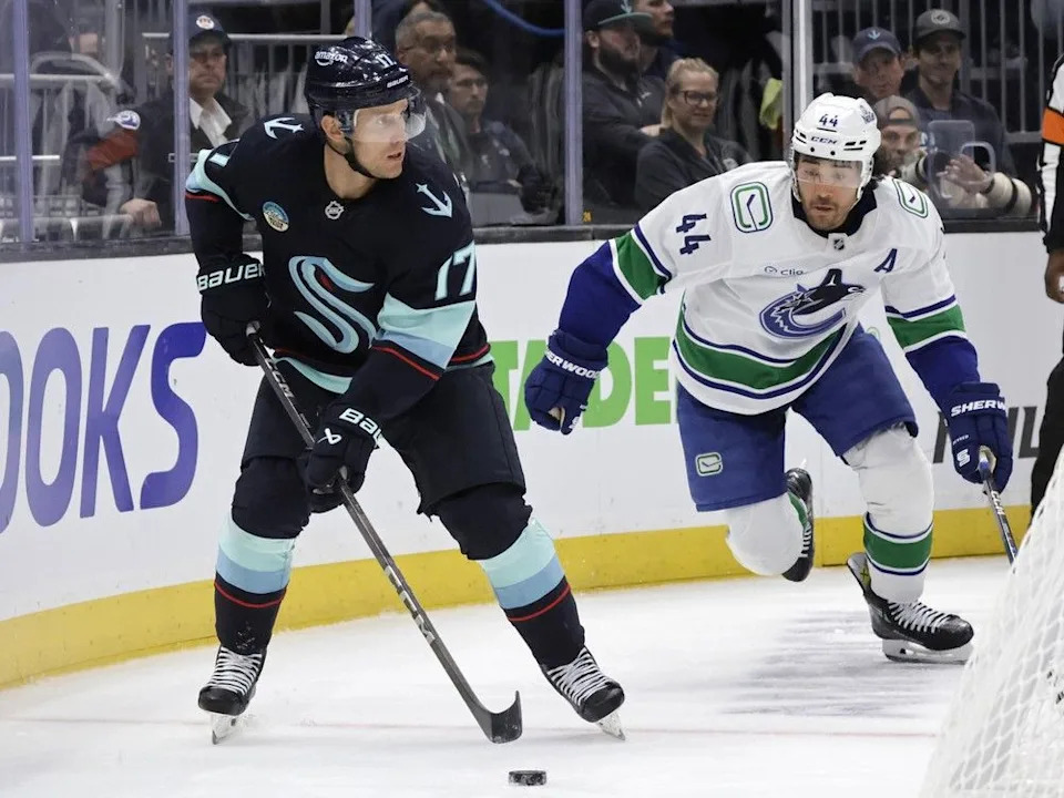  Seattle Kraken left wing Jaden Schwartz (17) skates with the puck behind the goal with Vancouver Canucks left wing Kiefer Sherwood (44) behind during the third period of a preseason NHL hockey game Sunday, Sept. 21, 2025, in Seattle.