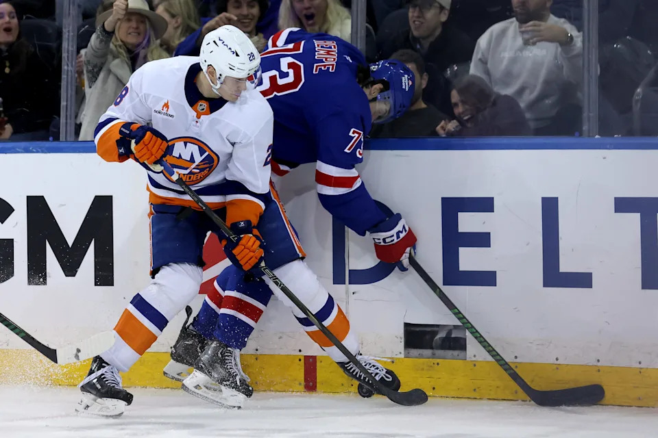 Mar 3, 2025; New York, New York, USA; New York Islanders defenseman Alexander Romanov (28) and New York Rangers center Matt Rempe (73) fight for the puck during the third period at Madison Square Garden. Mandatory Credit: Brad Penner-Imagn Images