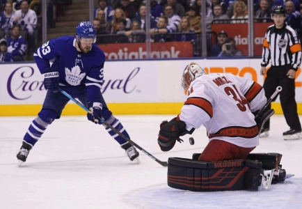 Feb 22, 2020; Toronto, Ontario, CAN; Carolina Hurricanes goaltender Petr Mrazek (34) makes a save on Toronto Maple Leafs forward Frederik Gauthier (33) during the first period at Scotiabank Arena. Mandatory Credit: John E. Sokolowski-Imagn Images