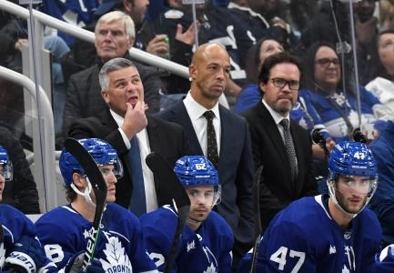 Oct 8, 2022; Toronto, Ontario, CAN; Toronto Maple Leafs head coach Sheldon Keefe (left) looks up at the scoreboard as assistant coaches Manny Malhotra (center) and Dean Chynoweth look on during a break in play against the Detroit Red Wings at Scotiabank Arena. Mandatory Credit: Dan Hamilton-Imagn Images