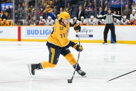 Apr 8, 2025; Nashville, Tennessee, USA; Nashville Predators right wing Luke Evangelista (77) takes a shot on goal against the New York Islanders during the first period at Bridgestone Arena. Mandatory Credit: Steve Roberts-Imagn Images