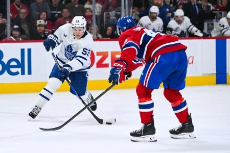 Sep 25, 2025; Montreal, Quebec, CAN; Toronto Maple Leafs forward Easton Cowan (53) shoots the puck against Montreal Canadiens center Jared Davidson (49) during the second period at Bell Centre. Mandatory Credit: David Kirouac-Imagn Images