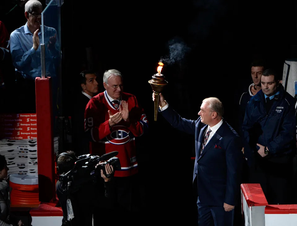 Montreal Canadiens head coach Michel Therrien with the torch and former goalie Ken Dryden during the introduction ceremony.