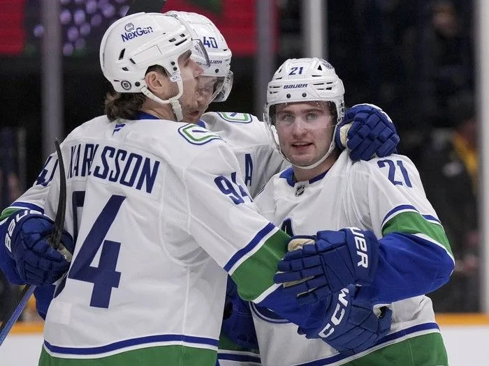 Nils Hoglander is congratulated by Linus Karlsson and Elias Pettersson after scoring against the Nashville Predators on Jan. 29.