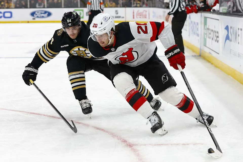 New Jersey Devils center Michael McLeod (20) tries to hold off Boston Bruins center Jakub Lauko (94) during the second period at TD Garden. 