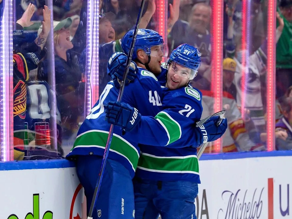 Nils Hoglander is congratulated by linemate Elias Pettersson after scoring against the Calgary Flames on April 16, 2024.